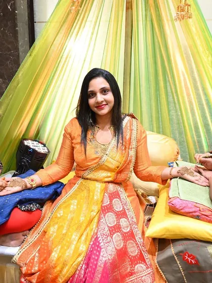 A bride enjoying her Mehendi ceremony, seated in a beautifully draped setting. We ensure the bride is comfortable while her henna is applied.