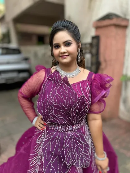 A full portrait showing the stunning purple gown and the glamorous makeup and hairstyle.
