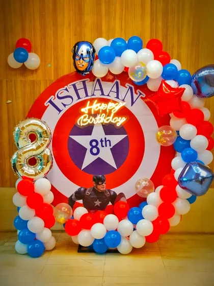 An Avengers theme is always a hit, and this Captain America setup was for an 8th birthday. I used a custom backdrop of the iconic shield, a balloon garland in red, white, and blue, and the birthday boy's name integrated into the design.