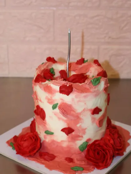 Another shot of our passionate red rose cake, with textured buttercream and a single candle.