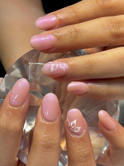 Elegance in every petal. This delicate design features a sheer, pearlescent pink base with subtle, hand-painted white leaf accents.