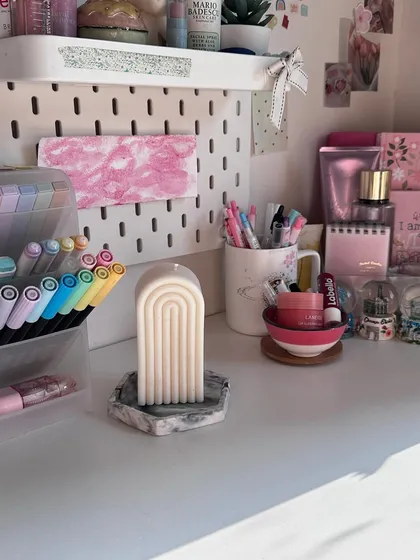 Our arch candle styled on a desk with a marbled trinket tray. It's the perfect accessory for a chic and organized workspace.