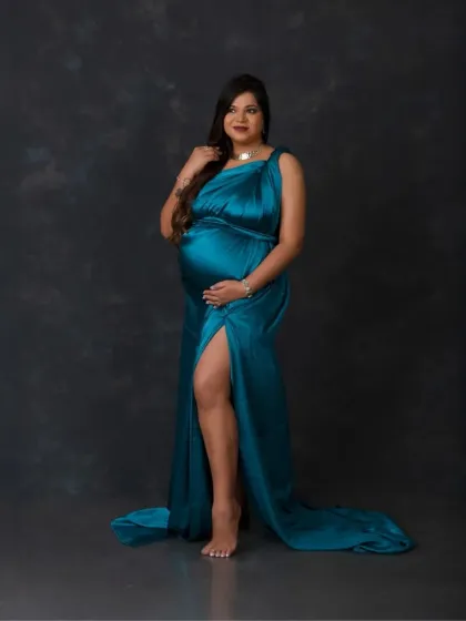 A confident and powerful stance. The rich teal fabric and the simple dark background put all the focus on the beautiful mother-to-be.