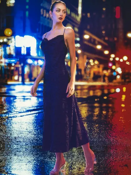 This nighttime city street, with its vibrant neon lights, is a projected backdrop. The lighting on the model is designed to look like it's coming from the neon signs, creating a cohesive and dynamic urban scene.