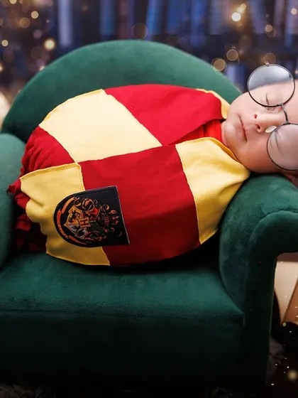 The chosen one! A sleeping newborn with Harry Potter's iconic glasses, swaddled in a Gryffindor scarf.