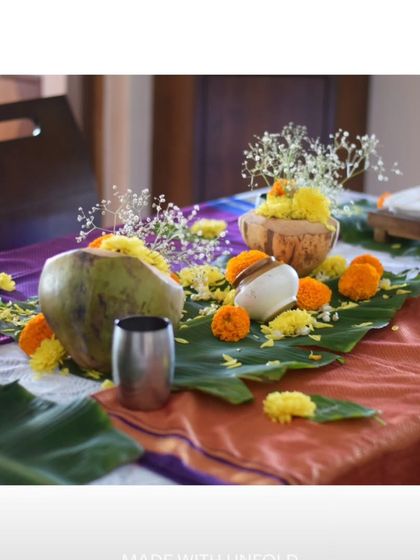 The decor for my home dining experience is all about warmth and tradition. Coconuts, marigolds, and banana leaves set the stage for a memorable meal filled with authentic Indian flavours.