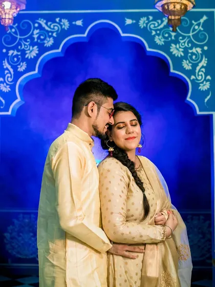 A close-up of the couple in traditional attire. Her makeup is soft and glowing, with a focus on her eyes.