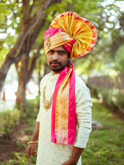 A three-quarter portrait that highlights the traditional necklace and the texture of the kurta.