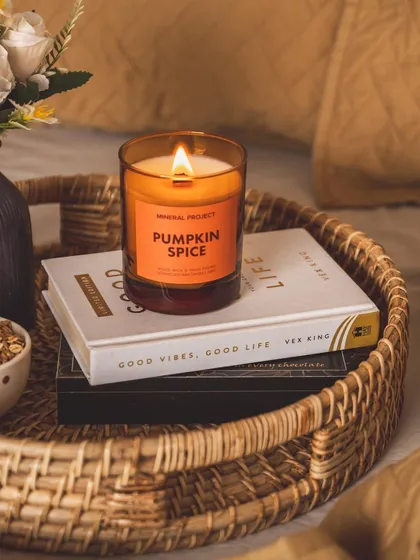 A "breakfast in bed" scene styled with a book and a scented candle. This aspirational lifestyle shot connects the product with moments of peace and self-care.