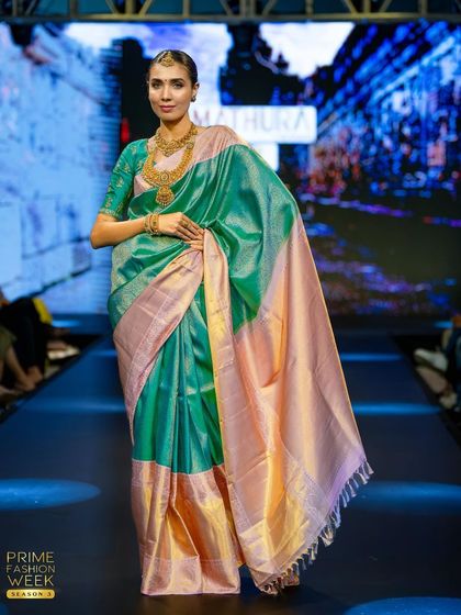 A beautiful sea-green and peach Kanchipuram silk saree, its soft pastel tones creating a look of ethereal grace on the runway.