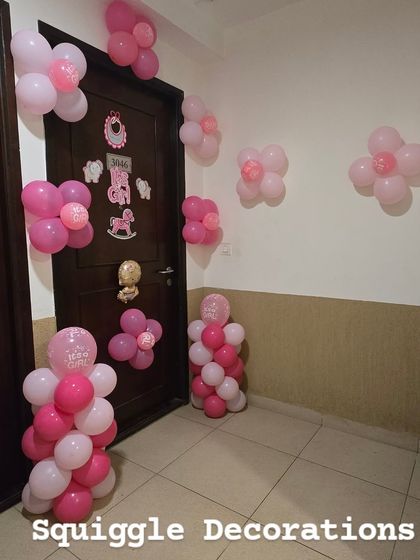 Simple and sweet 'It's a Girl' decorations for a baby's arrival, featuring pink balloon flowers and cutouts to decorate the entrance and hallway.