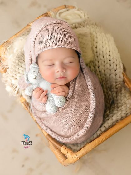 Snuggled up with a tiny teddy bear, this little one is perfectly content. I use soft wraps and props like this to ensure the baby is comfortable and secure throughout the newborn session.