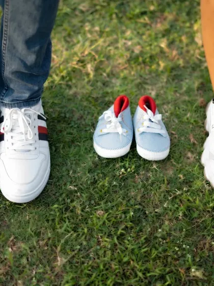 A fun detail shot for an outdoor shoot, featuring the shoes of the parents-to-be alongside a tiny pair for the baby.