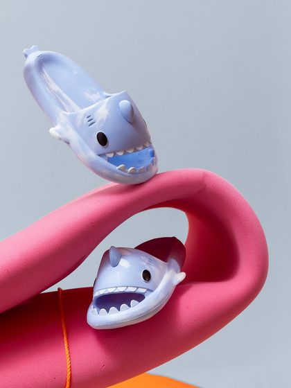 A close-up of the shark clogs interacting with a curved pink prop, creating a fun and imaginative scene that appeals to both kids and parents.