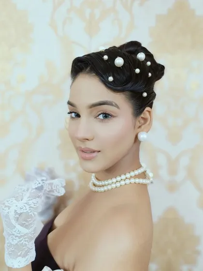 A close-up of a vintage-inspired updo from a themed editorial shoot. I meticulously crafted finger waves at the front and arranged a clean bun, scattering pearls throughout the hair for a touch of classic Hollywood glamour.