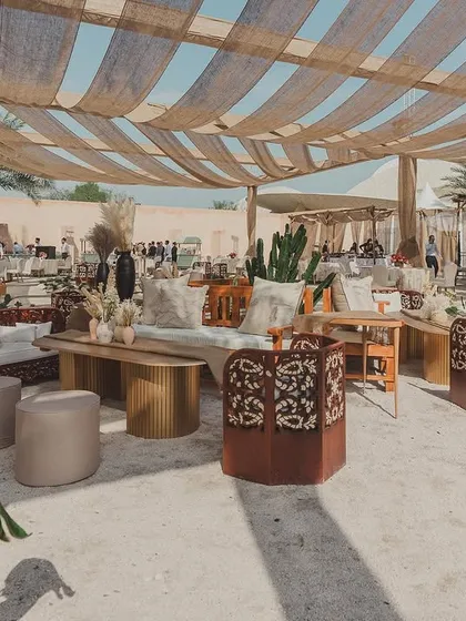 The lounge setup for the cultural event in Doha, featuring earthy tones, natural textures, and comfortable seating, creating a modern Arabian vibe.