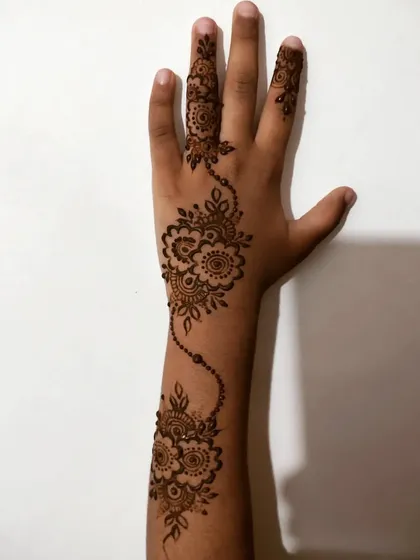 A delicate floral vine trailing up a child's arm.