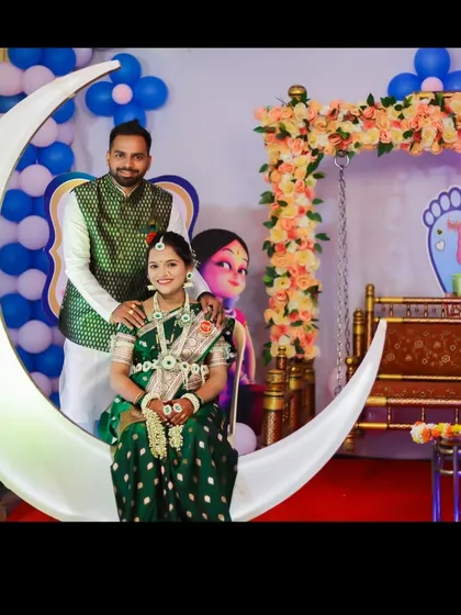 Capturing the joy of the parents-to-be is what it's all about. Here, a couple poses on an illuminated crescent moon prop, a popular photo-op I provide as part of my baby shower decoration services in the Thane area.