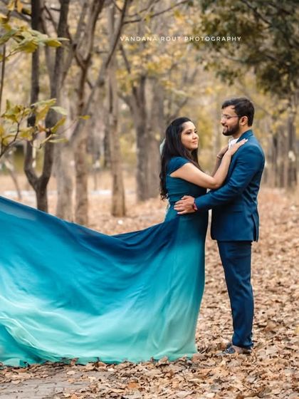 The forest becomes a ballroom in this enchanting shot. The movement of the long, flowing trail of the gown adds a dynamic and whimsical element to this nature-based pre-wedding photo.