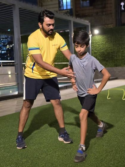 We focus on the fundamentals of athletic movement. A coach provides hands-on correction during a lunge, ensuring the young athlete builds lower body strength safely and effectively to prevent injury.