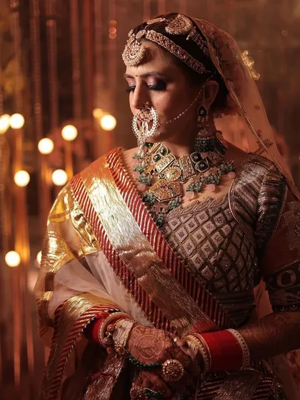 A candid moment of the bride, beautifully lit to highlight the sparkle of her jewellery against the rich fabrics of her outfit.