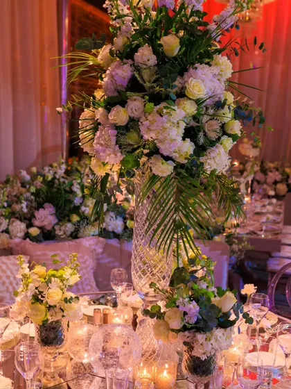 A close-up of the tablescape from the Istanbul celebration, featuring towering crystal vases with white floral arrangements and countless candles, exuding pure opulence and romance.