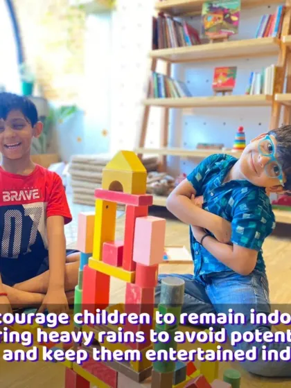 Two boys collaborating on a colorful block structure. This shows how simple toys can encourage teamwork and social interaction, even on a rainy day.