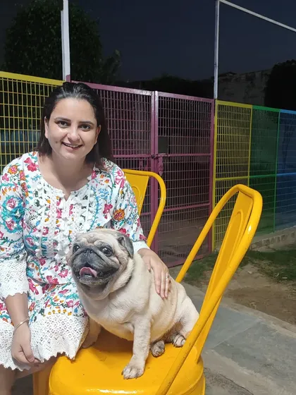 A smiling Manpreet poses with a happy Pug. Our team's love for animals shines through in every interaction, creating a warm and welcoming atmosphere.