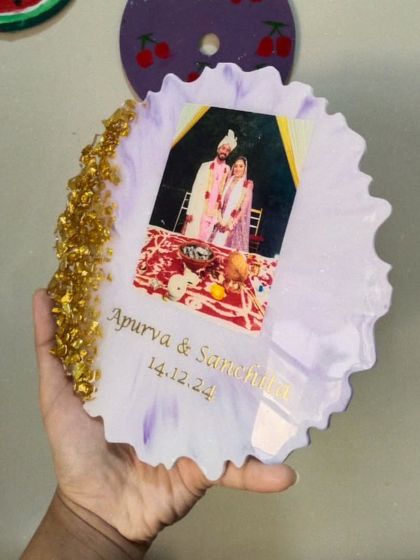 A custom resin photo frame created as a wedding gift. The couple's photo is embedded in a soft purple and white resin base, with their names and wedding date inscribed below.