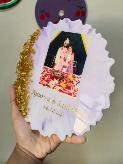 A custom resin photo frame created as a wedding gift. The couple's photo is embedded in a soft purple and white resin base, with their names and wedding date inscribed below.