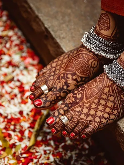 The final result is everything. This photo shows the beautiful, dark henna stain on the feet, achieved with my all-natural paste. The design features classic peacock motifs and intricate check patterns.
