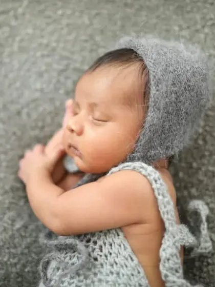 So sleepy and content in a hand-knitted outfit. I have a collection of delicate props like this to make your newborn's first photoshoot extra special.