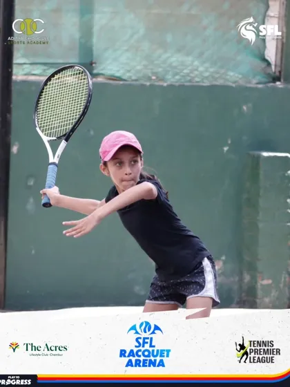 A young player in a pink cap executes a powerful forehand during a match. Her dynamic movement showcases the athleticism we develop in our players.