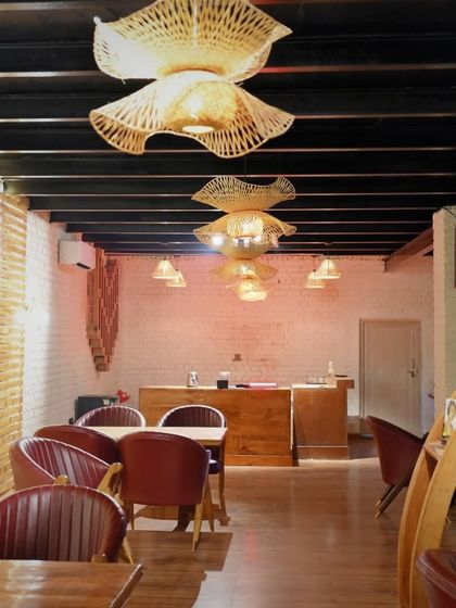 A wider view of our indoor dining area, showing the unique woven light fixtures and the warm, inviting tones of the decor.