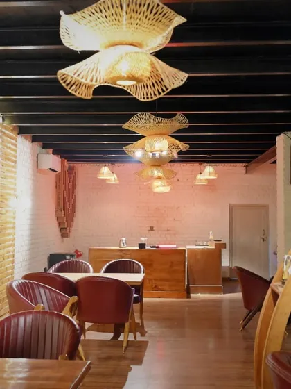 A wider view of our indoor dining area, showing the unique woven light fixtures and the warm, inviting tones of the decor.