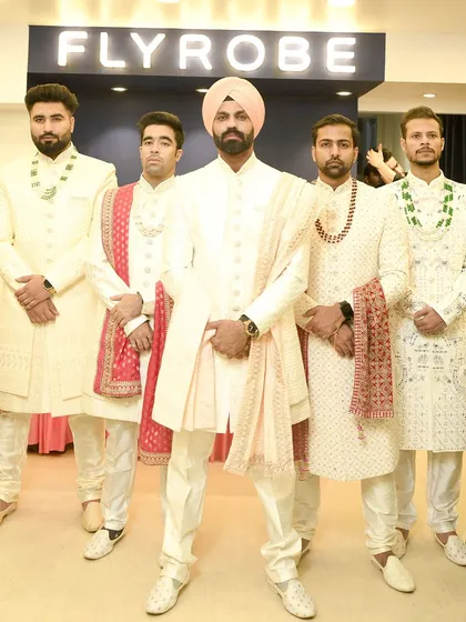 Here’s how you coordinate the groom and his squad. The dulha stands out in a turban while the groomsmen wear matching ivory sherwanis for a powerful, unified look.