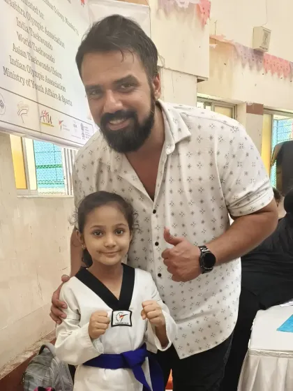 A proud moment for our student Zainab, posing with a supporter after her gold medal win. The support of family and friends is a huge part of a martial artist's journey.