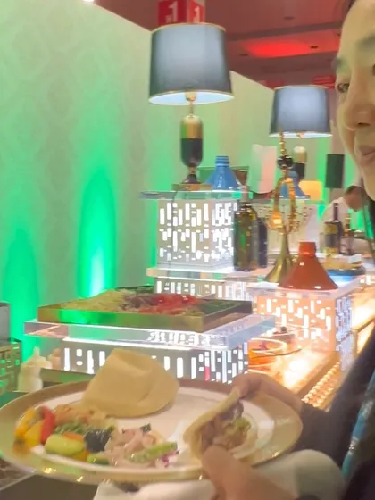 A guest enjoys a plate filled with a variety of our offerings, showcasing the global journey we provide at a single event.