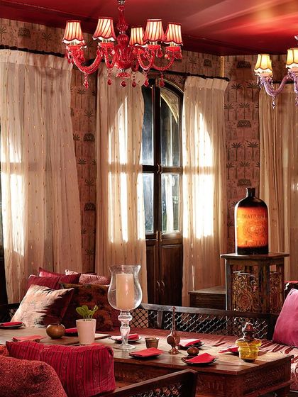 The sun streams through our arched windows, illuminating the rich red and gold details of our private dining area. It's an ambiance that feels both grand and intimate.