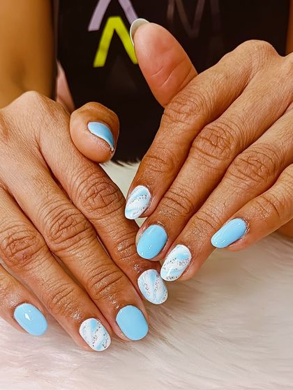 A soft and pretty set featuring baby blue nails with a sparkling silver marble accent.