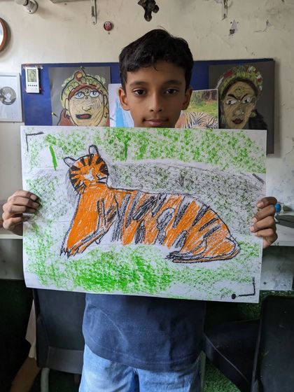 This student chose to draw a tiger, capturing the animal's form and stripes with expressive oil pastel strokes on a green background.
