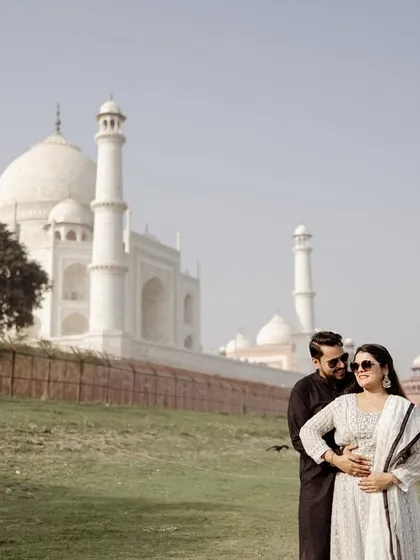 A candid moment by the riverbank, with the Taj Mahal in the distance. This shows a different, more rustic side of the location, adding variety to your Agra pre-wedding album.