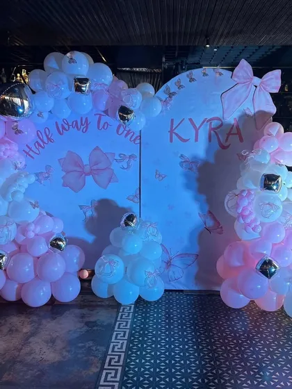 The complete photo booth setup for the "Half way to one" party, with soft blue lighting enhancing the pink and white decor.