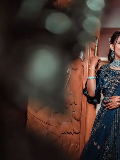 A creative reception portrait, shot through a foreground element to create a sense of looking in on a private, romantic moment.