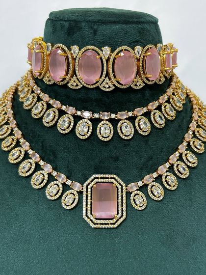 A stunning necklace set with pink stones and American diamond detailing. This rental set includes a choker and a matching necklace for a layered look.
