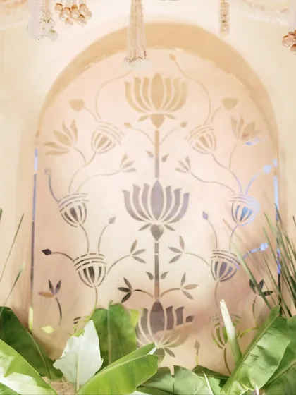 The lotus panel detail, framed by fresh banana leaves, brings a touch of organic, tropical elegance to the otherwise formal and regal stage design.