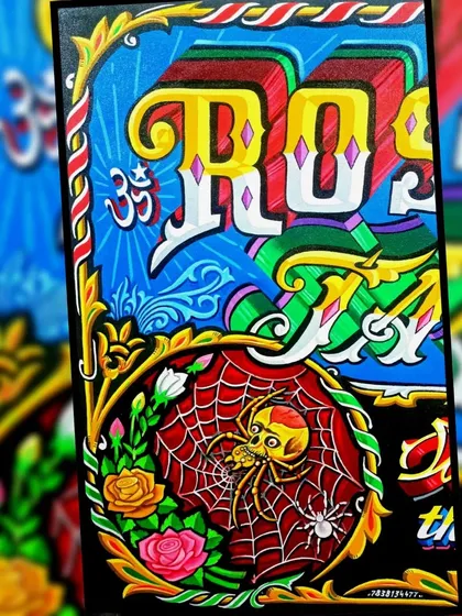 A close-up of the spider and rose from the Rose & Web Tattoo sign.
