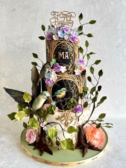 An enchanted garden theme for a special birthday. This three-tiered cake features hand-painted panels, sculpted branches, and delicate sugar birds and flowers. It was a labour of love.