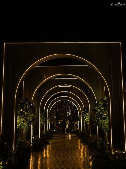The dramatic arched tunnel entrance to our 'Lemon Garden' sangeet, with integrated lighting creating a spectacular welcome for guests.