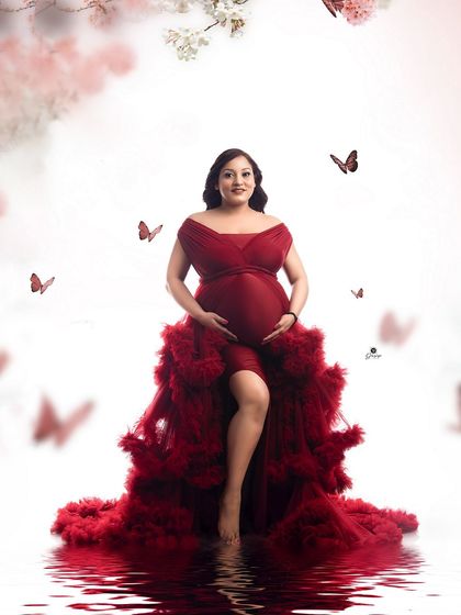 A stunning portrait featuring a rich red ruffled gown. The water reflection and floating butterfly effects add a layer of magic and whimsy to this glamorous shot.